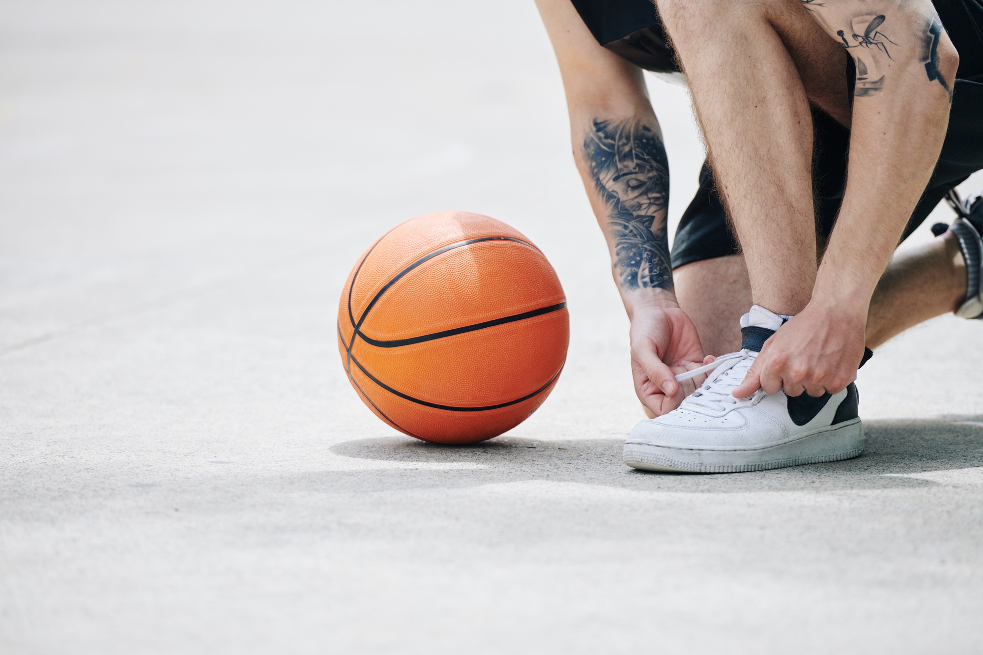 Basketball player tying sports shoe